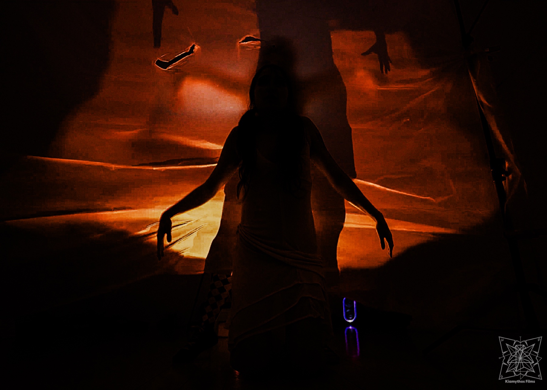 A silhouetted Temple of Ham performer in front of red and violet projection light for Syzygy Arts Collective.